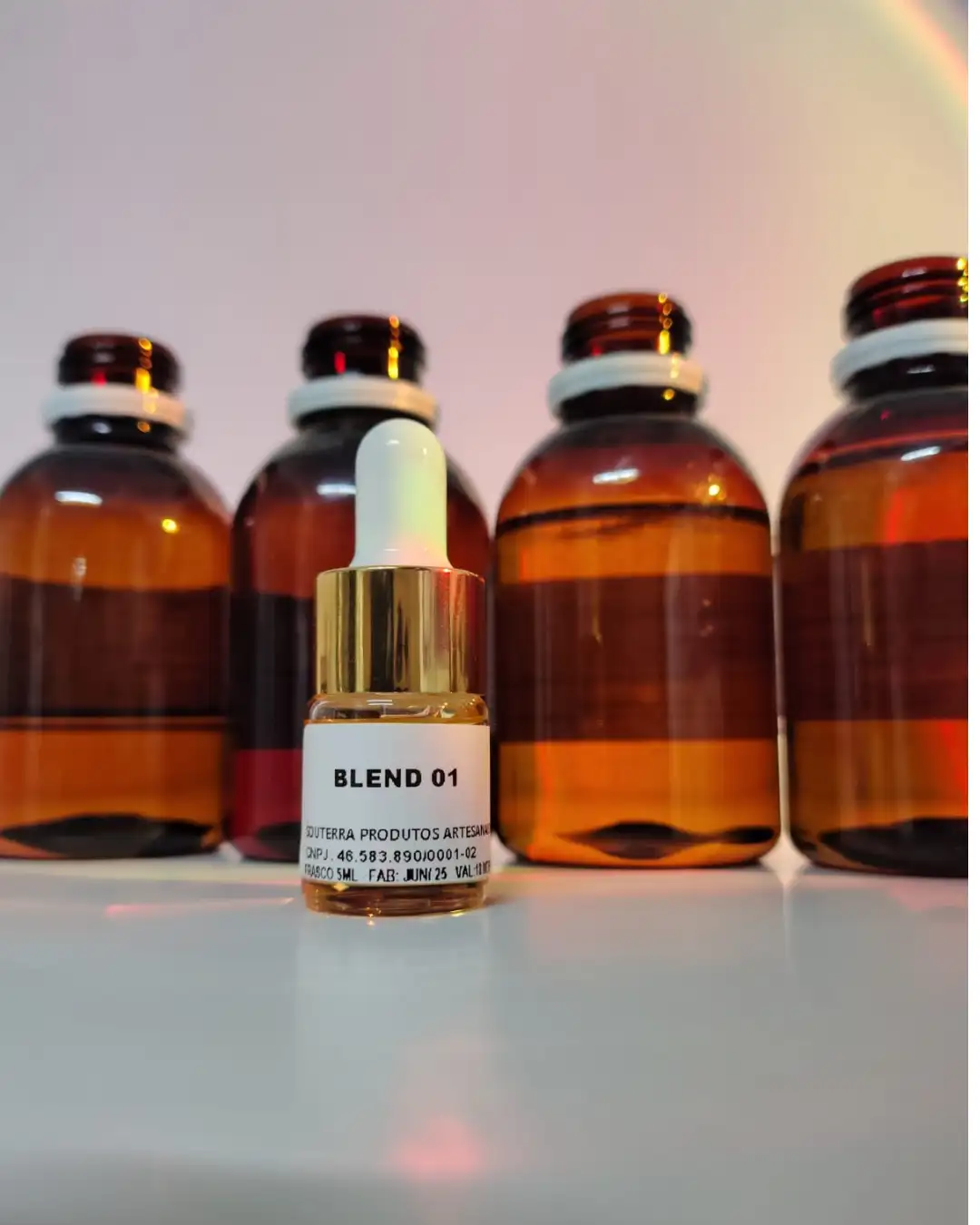 Frasco Blend 01 da SouTerra à frente dos galões de essências